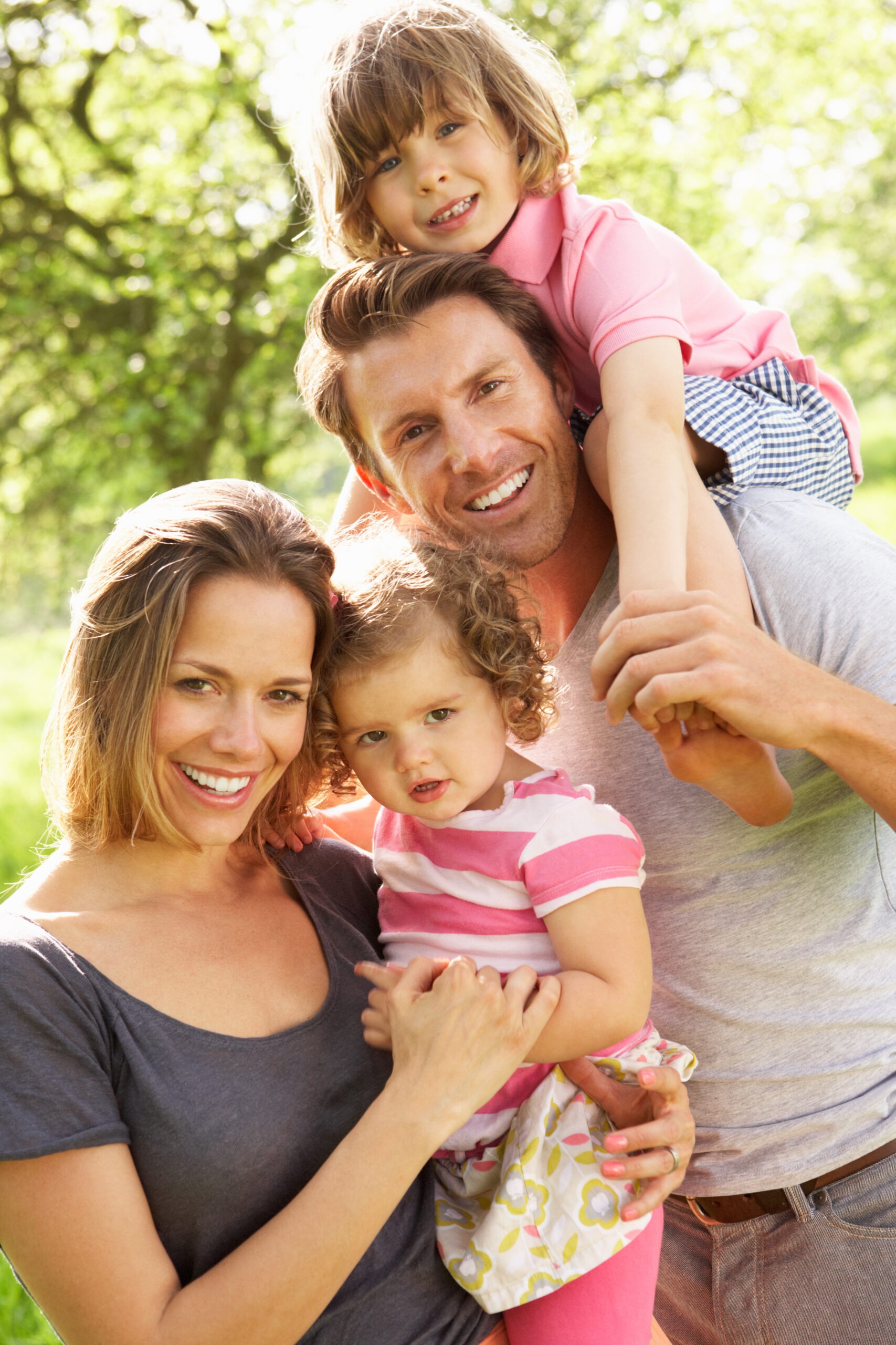 Parents Standing with Children in Field of Summer Flowers