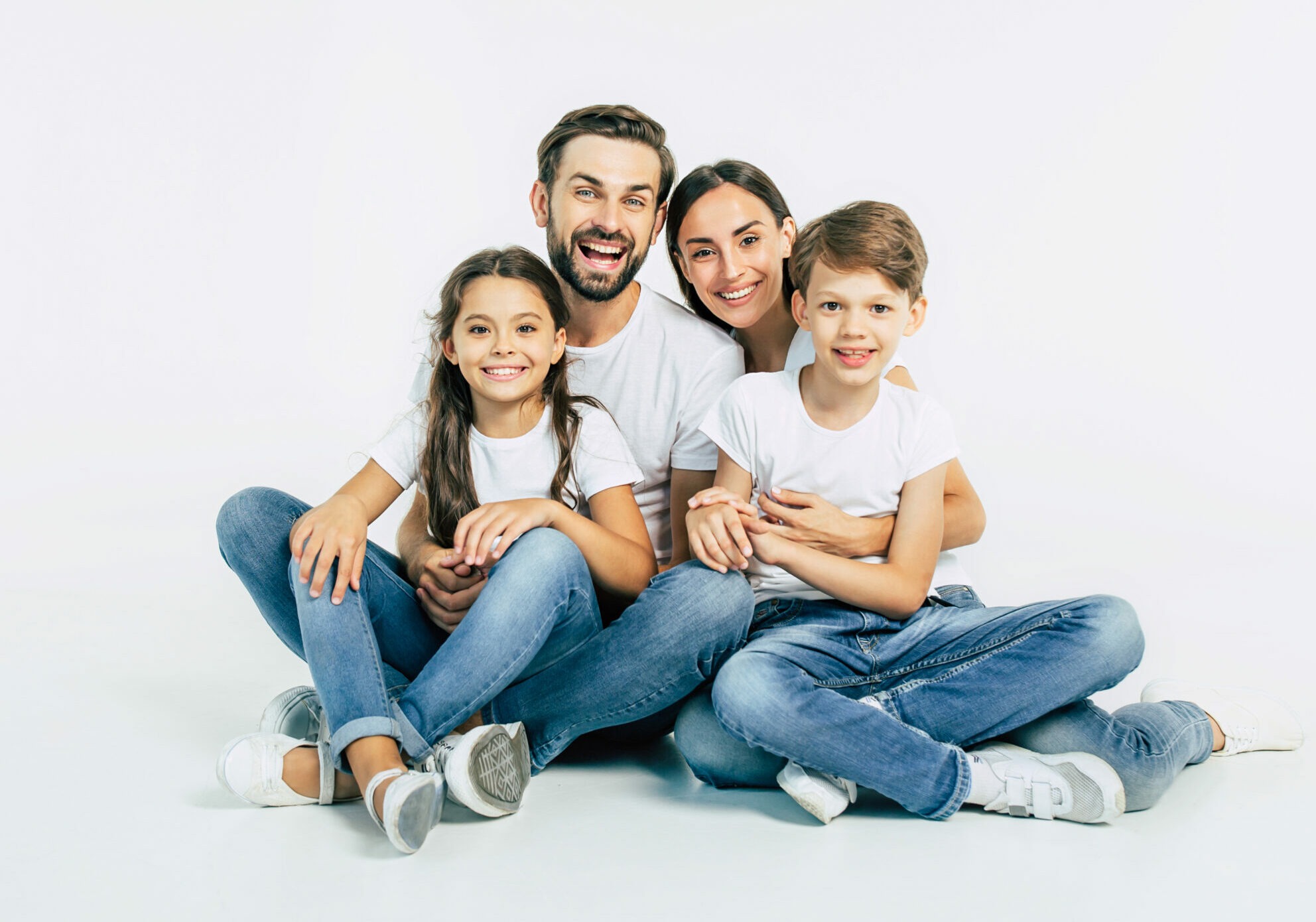 Beautiful and Happy Smiling Young Family in White T-Shirts